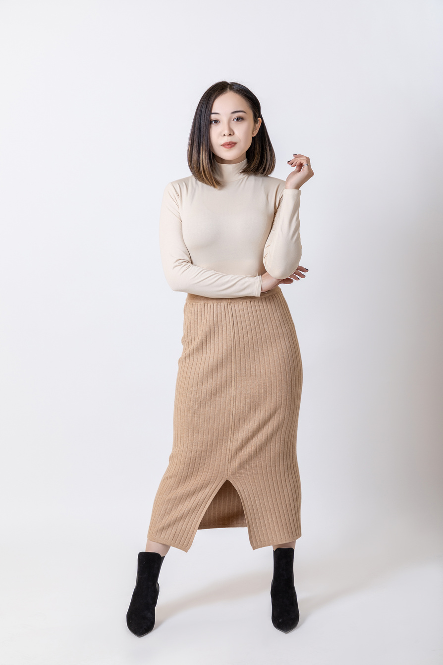 A Woman Posing in a Turtle Neck and a Skirt